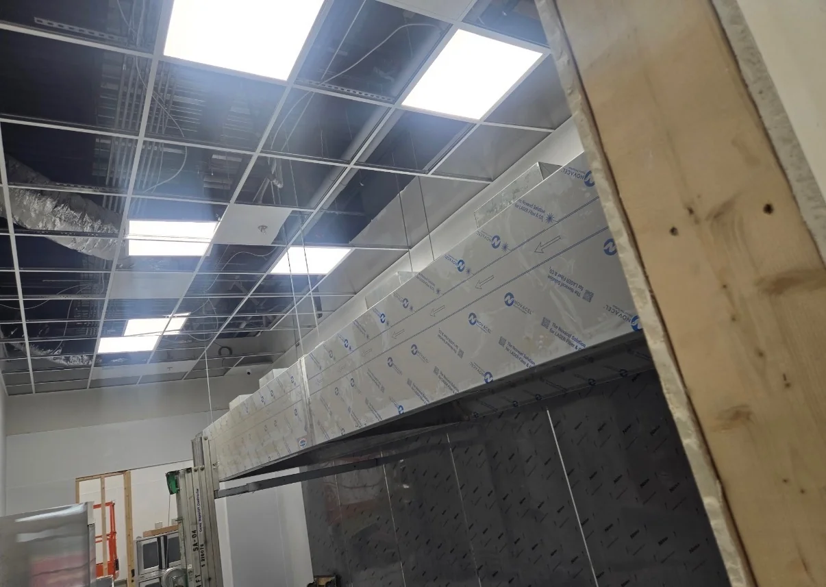 Ceiling lighting and wiring in a commercial interior.