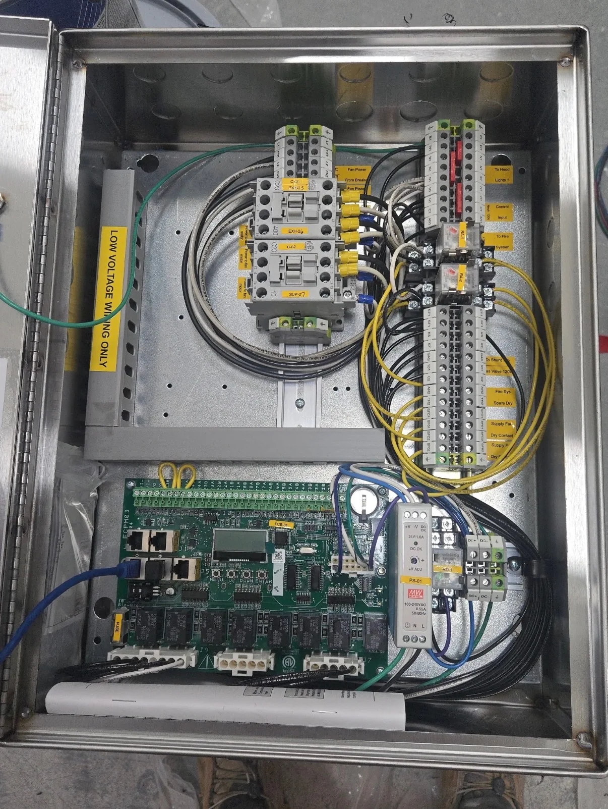 Open electrical control cabinet with wiring and relays.