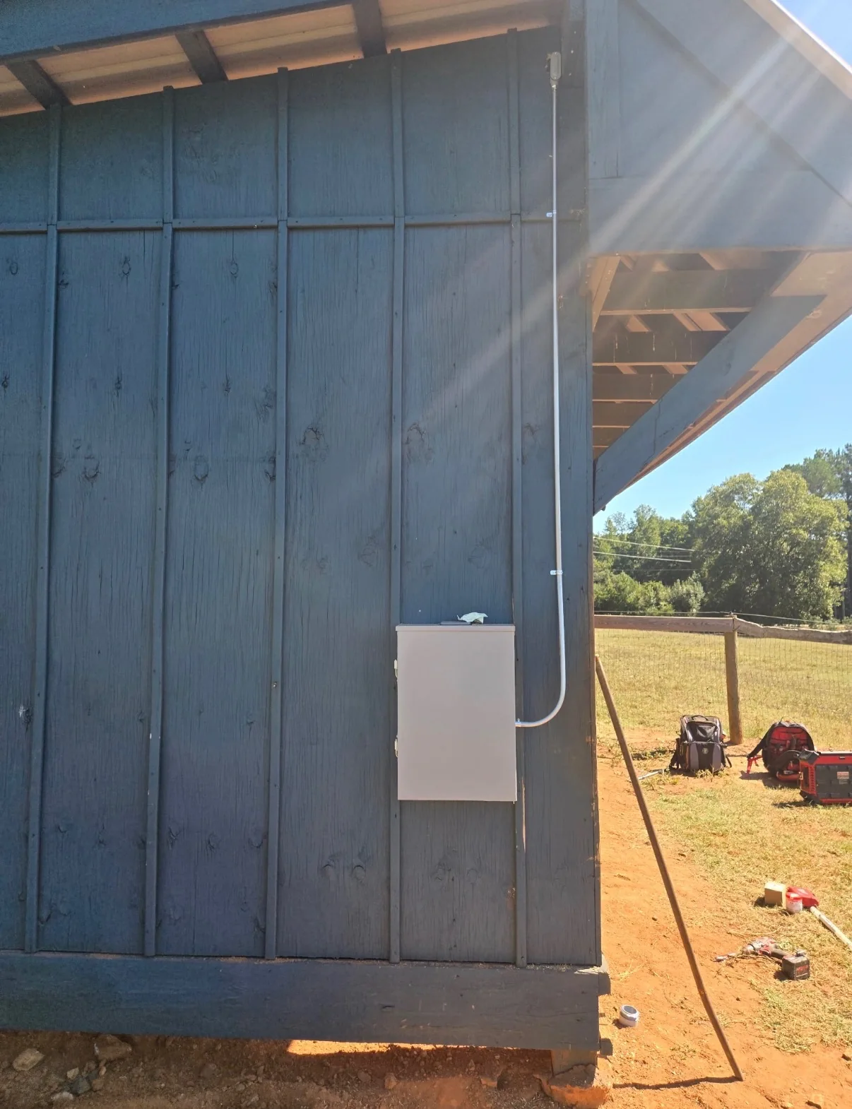 Wall-mounted electrical enclosure and conduit on a building exterior.