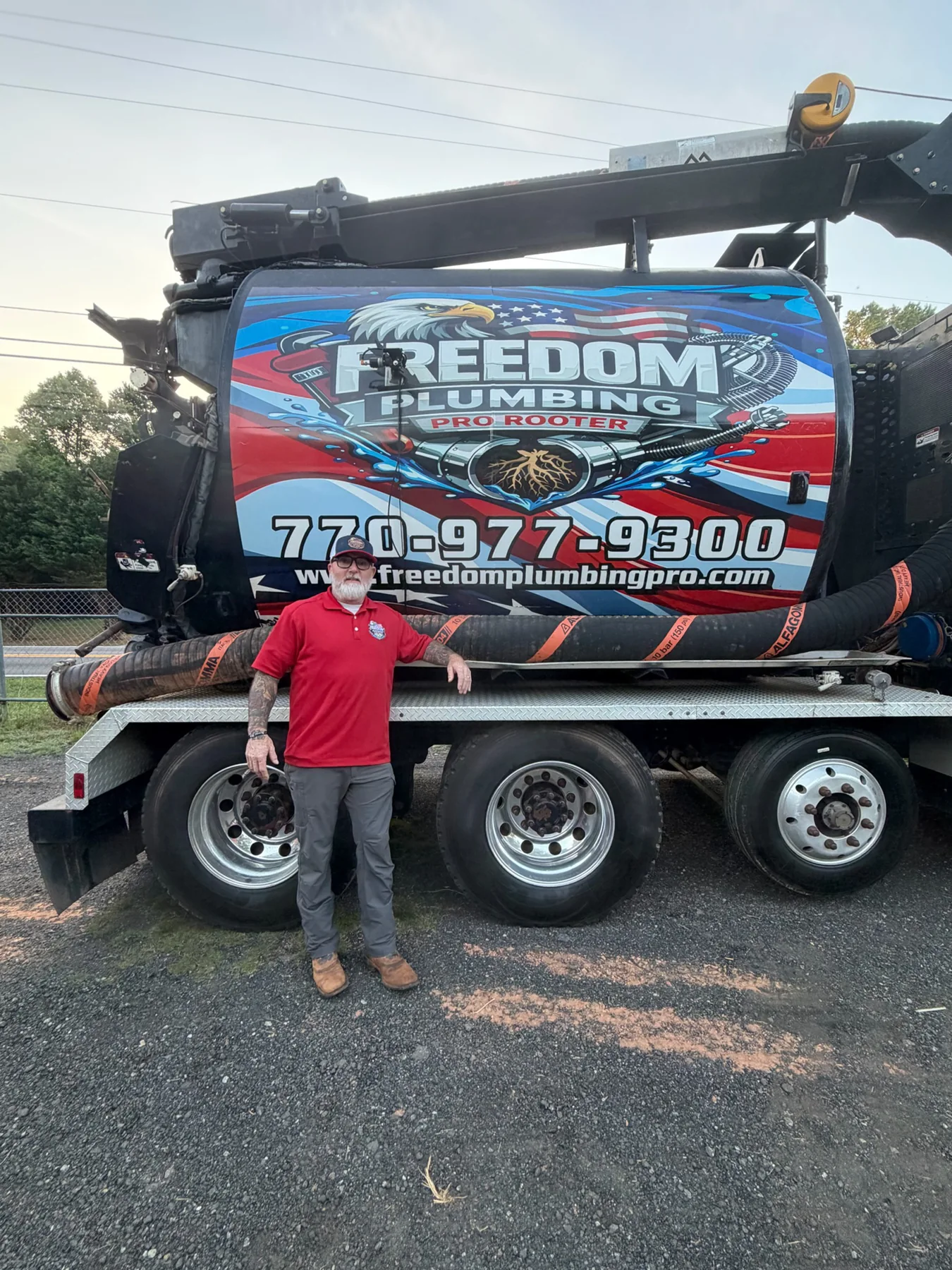 Person beside a Freedom-branded vacuum truck.