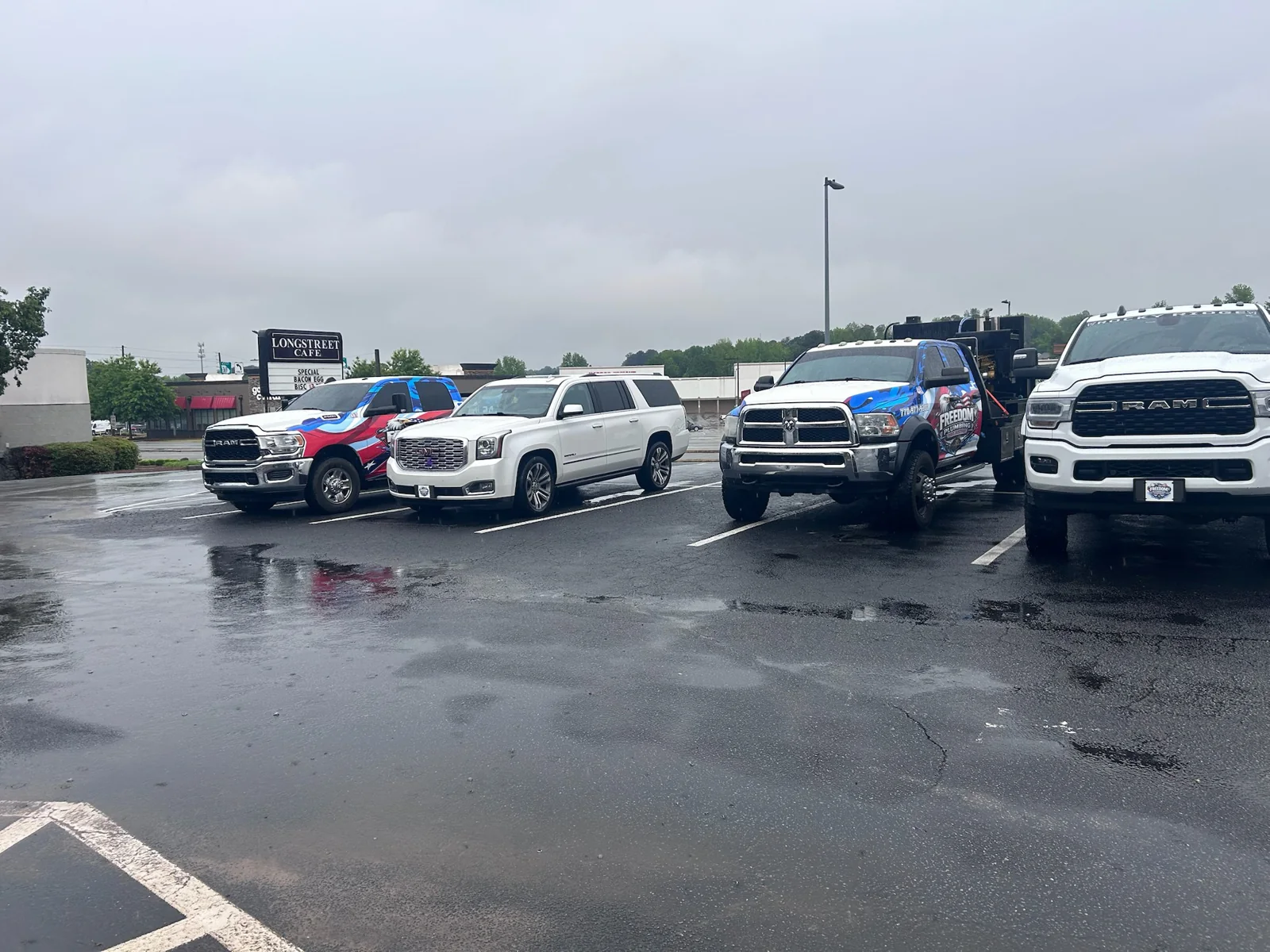 Freedom-branded trucks and other vehicles parked in a paved lot.