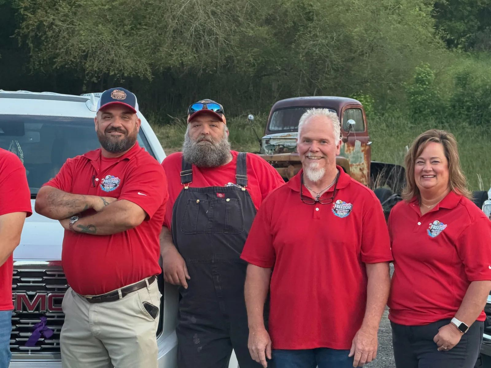 Four people in Freedom apparel together beside a truck.