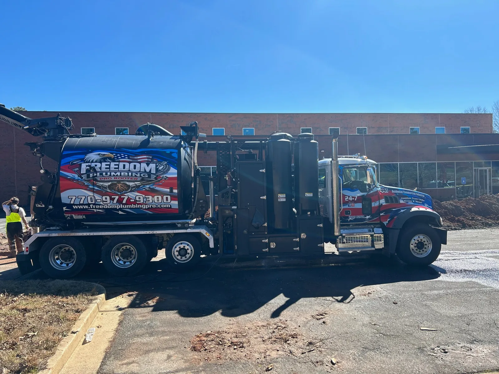 Freedom-branded vacuum truck at an outdoor work site.